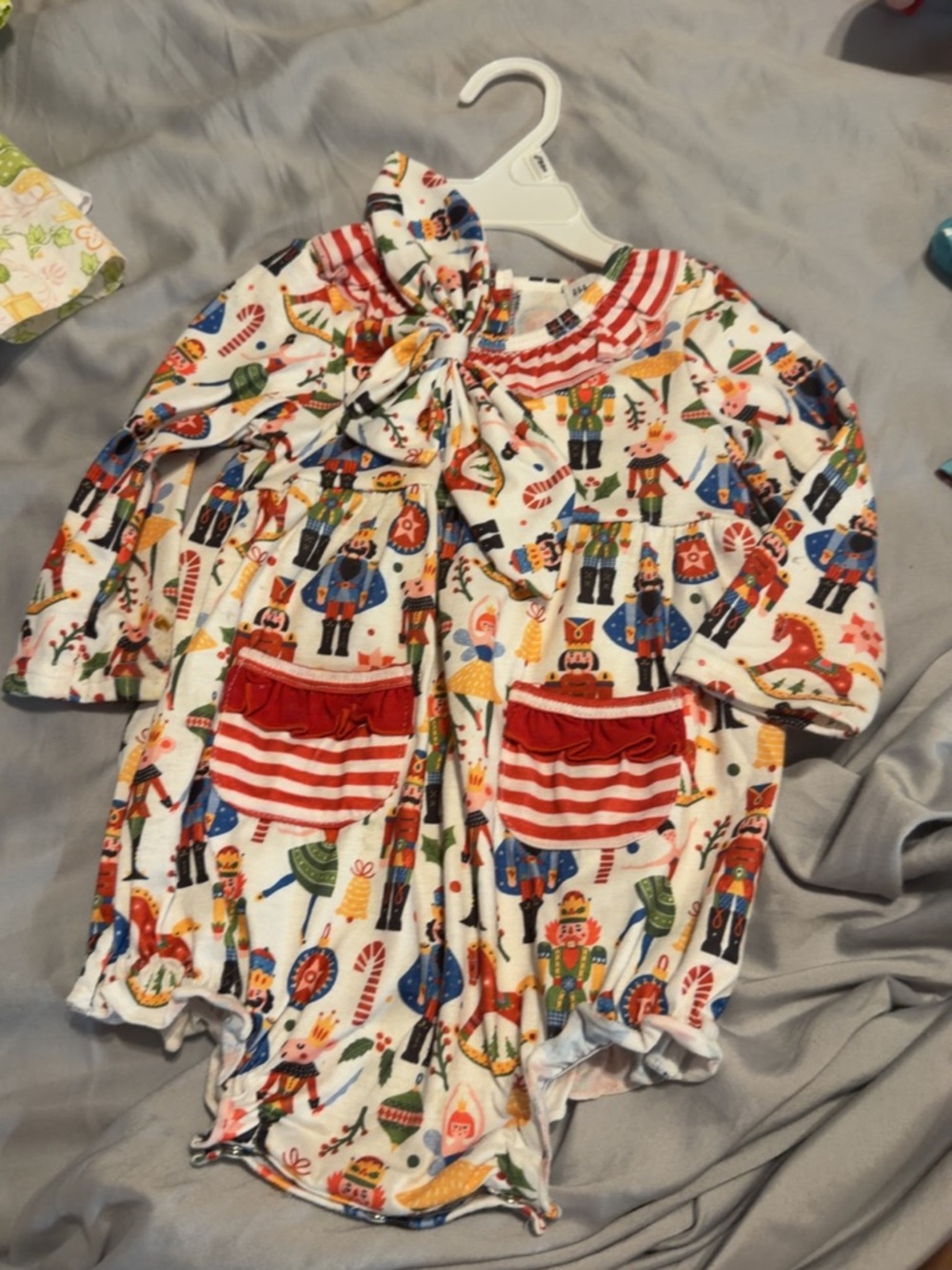 Holiday Nutcracker Print Baby One-Piece Footie with Red Pocket Accents
